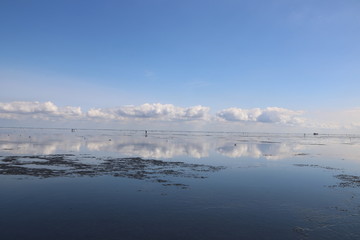 Idylle an der Nordsee -  Wattenmeer vor Cuxhaven bei ablaufendem Wasser mit Spiegelung von Wolken