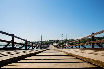 Perspective line from the lower view of long wood bridge. wide image for background, wallpaper, copy space, article and postcard. image for promote tourism. Mon Bridge, Sangkhla Buri, Kanchanaburi.