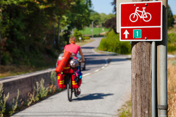 Cycle route sign with traveling cyclist in background Southern Norway