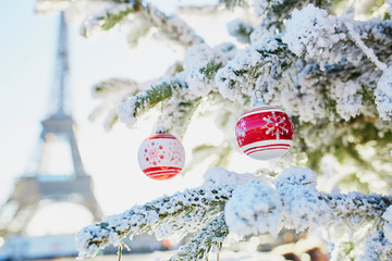 Christmas tree covered with snow near Eiffel tower