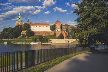 old medieval castle complex near river waterfront city district and outdoor park environment with road for walking in summer day time with blue color filter