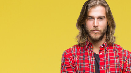Fototapeta premium Young handsome man with long hair over isolated background skeptic and nervous, disapproving expression on face with crossed arms. Negative person.