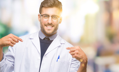 Young handsome man wearing doctor, scientis coat over isolated background looking confident with smile on face, pointing oneself with fingers proud and happy.