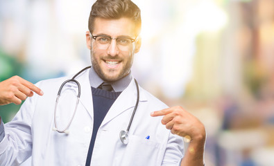 Young handsome doctor man over isolated background looking confident with smile on face, pointing oneself with fingers proud and happy.