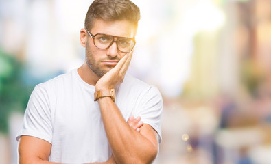 Young handsome man wearing glasses over isolated background thinking looking tired and bored with depression problems with crossed arms.