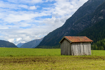 Fototapeta na wymiar A wooden cabin in the green fields of Tyrol, Austria