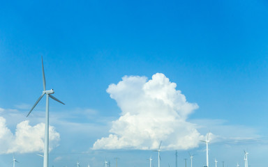 A wind turbine turning in a windy day with blue skies