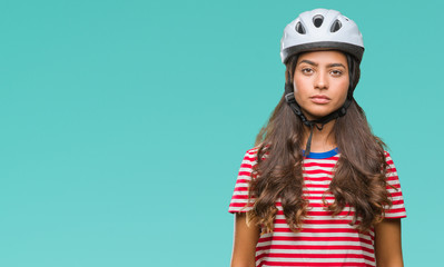 Young arab cyclist woman wearing safety helmet over isolated background with serious expression on face. Simple and natural looking at the camera.