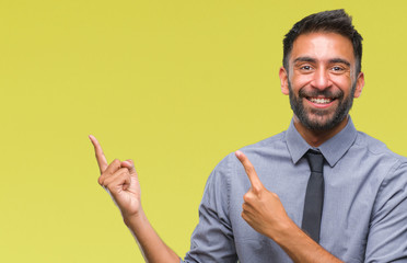 Adult hispanic business man over isolated background smiling and looking at the camera pointing with two hands and fingers to the side.