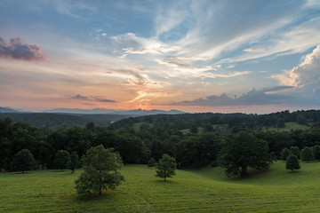 Sunset in the Mountains with Green Field