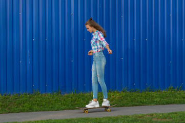 Slender young woman in jeans out skateboarding