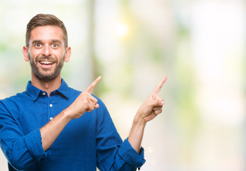 Young handsome man over isolated background smiling and looking at the camera pointing with two hands and fingers to the side.