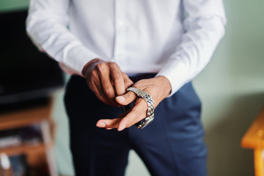 Close Up Of Man Putting Watch On His Hand.