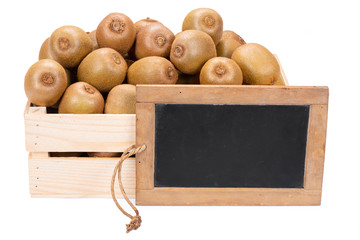 Wooden box filled with many ripe kiwi fruits and a old blank slate blackboard isolated on white...
