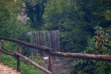 wooden bridge in the forest view of a beautiful waterfall 