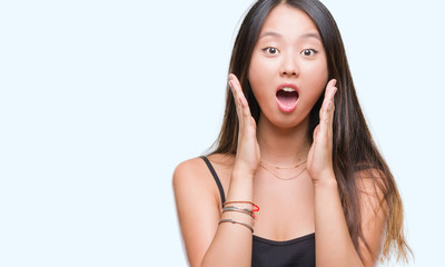 Young asian woman over isolated background afraid and shocked with surprise expression, fear and...