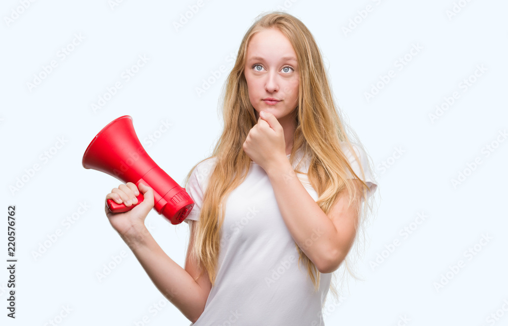 Canvas Prints Blonde teenager woman holding megaphone serious face thinking about question, very confused idea