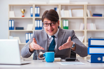 Businessman chained with handcuffs to his coffee