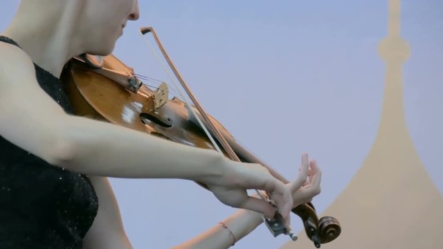 Symphony concert - unrecognizable woman playing fiddle - close up shot. Music and culture concept