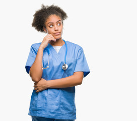 Young afro american doctor woman over isolated background with hand on chin thinking about...