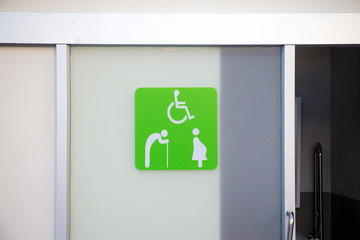 Green label on slice toilet door, priority for distable person in the oilbank station. priority benefits of the special people. image for objects, background, article and copy space.