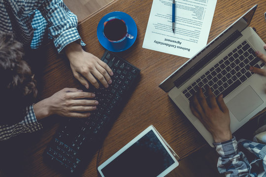 Overhead Top View Of Two Casual Businessmen Work In The Office At Table, Toned