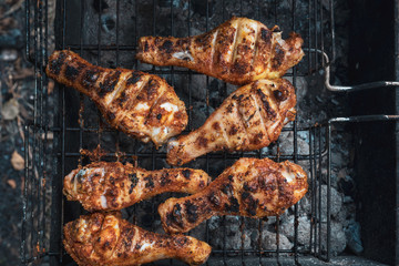 Grilled chicken thigh over flames on a barbecue