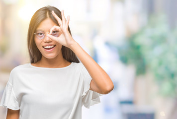 Young asian woman wearing glasses over isolated background doing ok gesture with hand smiling, eye looking through fingers with happy face.