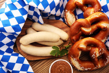 Bavarian veal sausage breakfast with sausages, soft pretzel and mild mustard on wooden board from...