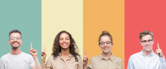 Collage of a group of people isolated over colorful background showing and pointing up with finger...