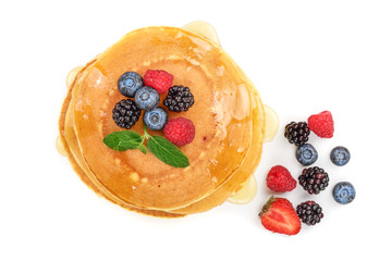 Pancakes stack with different berries isolated on white background. Top view. Flat lay