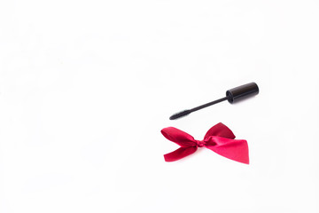 background with mascara and red ribbon