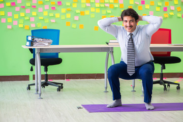 Man in the office with many conflicting priorities doing exercis