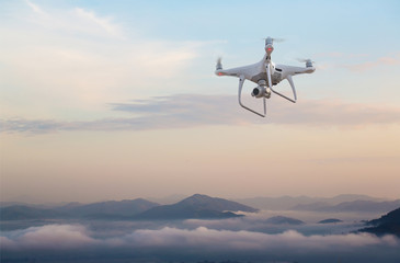 drone copter flying with digital camera.Drone with high resolution digital camera. Flying camera take a photo and video.The drone with professional camera takes pictures of the misty mountains.