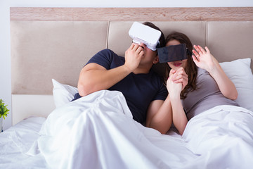 Obraz na płótnie Canvas Wife and husband with virtual reality goggles in the bed