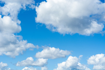 Naklejka na ściany i meble Blue bright summer sky with fluffy clouds on a sunny day