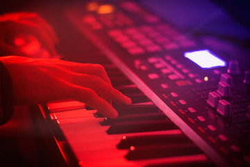 Keyboardist hands playing on synthesizer