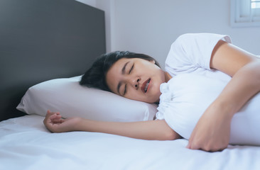 Women sleeping on the bed and grinding teeth,Female tiredness and stress - obrazy, fototapety, plakaty