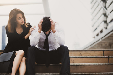 Couple with serious Tired depressed unemployed man sitting in city,Encouragement
 concept.