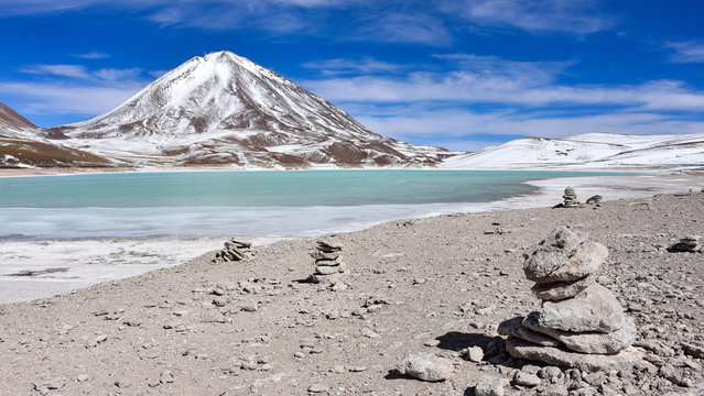 A rock pile stands in front of Laguna Verde and the Licancabur Volcano, Reserva Eduardo Avaroa, Sud Lipez province, Bolivia