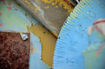 Closeup of rusted gear on machine with chipping blue and yellow paint