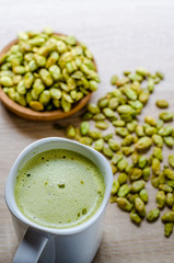 Edible seeds of hyacinth bean snack and green tea latte on wood background