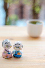 Grandfather and grandmother ceramic dolls on wooden ground