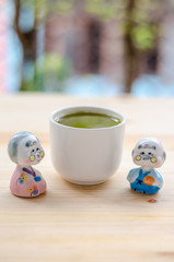 Grandfather and grandmother ceramic dolls on wooden ground