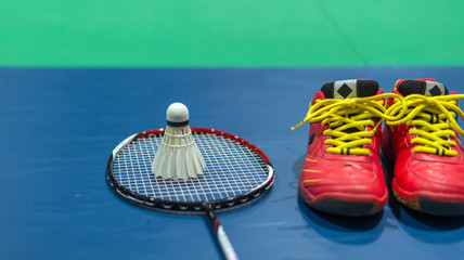 badminton shuttlecock with racket and red shoes  on court