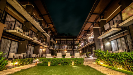 long exposure night shot image of poolside resort building with swimming pool and pool chairs along pool side at Lalune beach resort Samed island Rayong Thailand