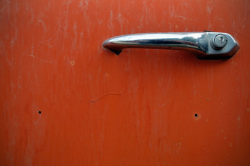 Chrome door handle on old red car