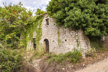 Fototapeta na wymiar Old abandoned stone-built house in Old Perithia at Pantokrator Mountain, Corfu Island, Greece