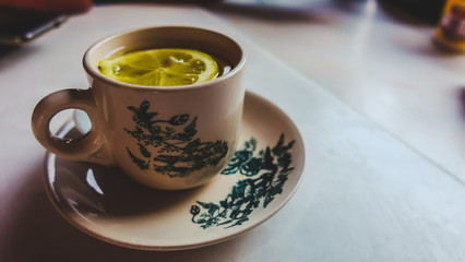 Obraz na płótnie Canvas Closeup shot of Hot lemon tea cup serve in white table in restaurant 