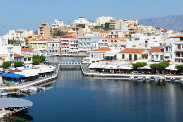 Fototapeta na wymiar Agios Nikolaos. Crete. Buildings on the shore of Voulismeni Lake and boats at the pier